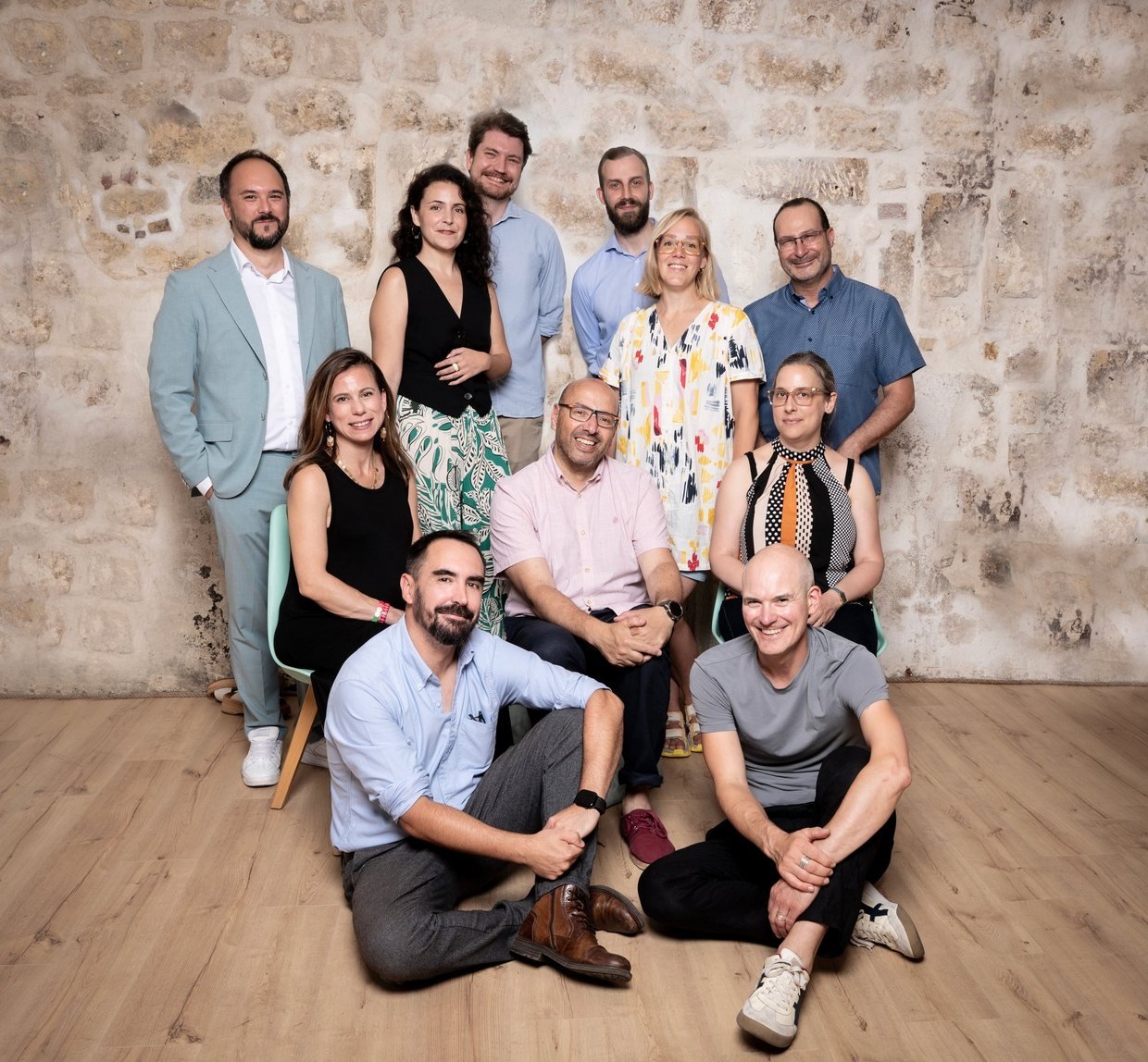 Les douze membres fondateurs de l’association ADELIE, réunis devant un mur de pierre.